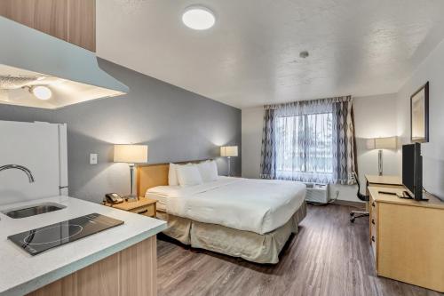Habitación de hotel con cama y lavabo en Suburban Studios Salt Lake City Airport en Salt Lake City