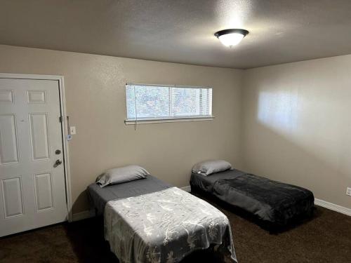 a room with two beds and a window and a door at Workforce Ready 2 bedroom in Corpus Christi