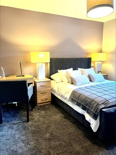 a bedroom with a bed and a desk with two lamps at Castle Rise in Hull