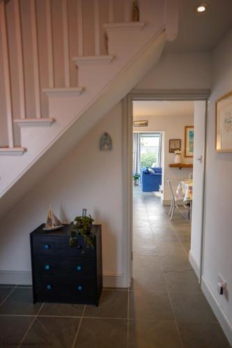 a hallway with a staircase and a dresser in a house at San Rocco in Bembridge