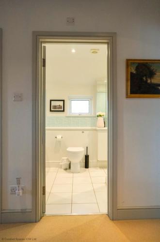 a bathroom with a toilet through a glass door at San Rocco in Bembridge
