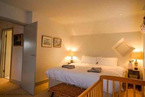 a bedroom with a large white bed with two towels on it at San Rocco in Bembridge