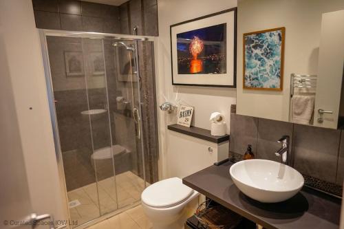 a bathroom with a shower and a toilet and a sink at San Rocco in Bembridge