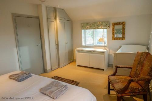 a bedroom with a bed and a chair and a desk at San Rocco in Bembridge