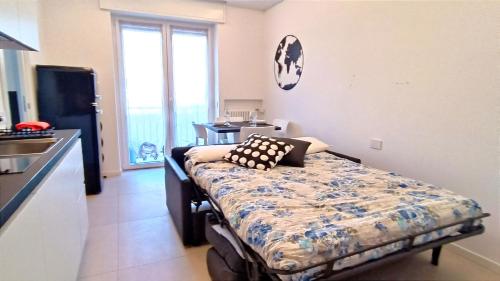 1 dormitorio con 1 cama y cocina con ventana en Alimagia, en Lecco