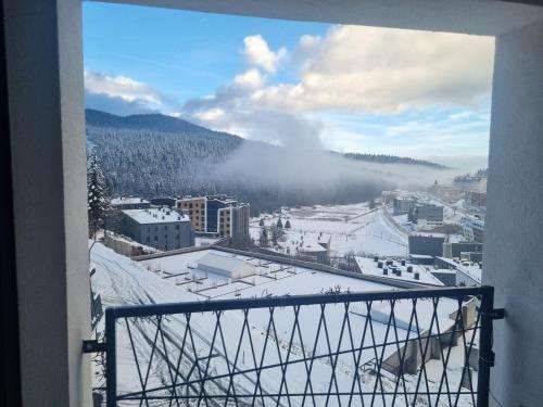 a view of a snow covered city from a balcony at Bjelasnica view lodge in Bjelašnica