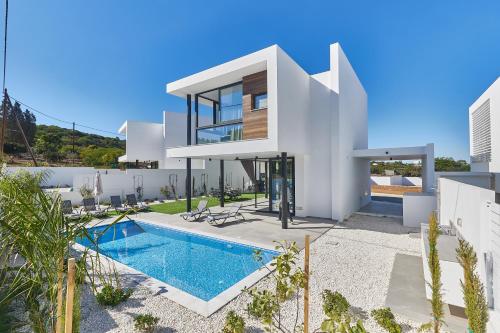 a villa with a swimming pool and a house at Elite Pearl Villas in Protaras