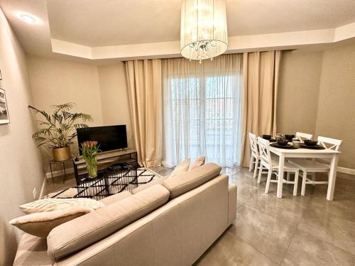 a living room with a couch and a dining room at Apartament nad Łyną by RENT4YOU in Olsztyn