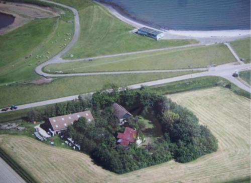 Luftblick auf ein Haus und eine Straße in der Unterkunft Stacaravan met tuin aan de Waddenzee in Oosterend