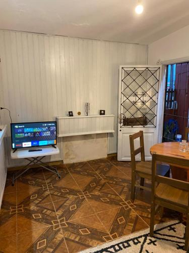 a living room with a television and a table at Casa de 1 Dormitorio ubicado en planta baja. A 150 mts de la playa en La Aguada y Costa Azul, La Paloma, Rocha in Costa Azul