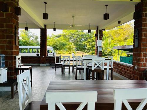 restauracja z białymi stołami i krzesłami w budynku w obiekcie Sky 14 Resort Yala w mieście Madam