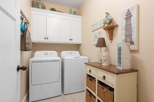 a laundry room with two washing machines and a table at Hot Tub Golf Cart Near beach Coastal Retreat in Bolivar Peninsula