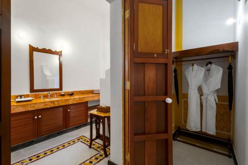 a bathroom with a door and a sink and a mirror at Hacienda San Antonio Millet in Tixkokob