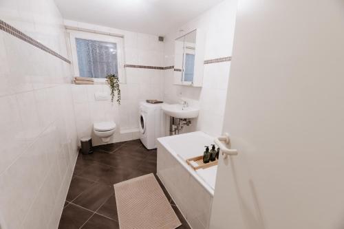 Baño blanco con lavabo y aseo en Altstadt Apartment Lemgo en Lemgo