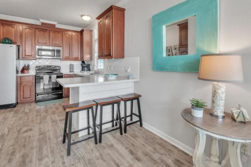 a kitchen with wooden cabinets and a table with stools at Steps to beach Golf Cart About Time Beach Retreat in Bolivar Peninsula