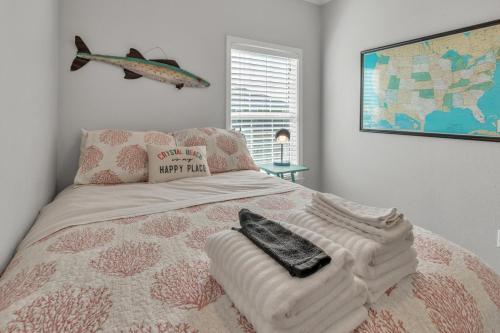 a bedroom with a bed with a comforter and a fish picture at Steps to beach Golf Cart About Time Beach Retreat in Bolivar Peninsula