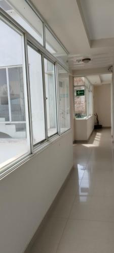 an empty room with windows and a white floor at Hotel Alta Vista Campestre in Tibasosa