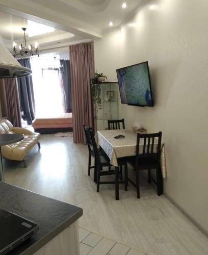 een keuken en een woonkamer met een tafel en stoelen bij VIP apart 419 in Tbilisi City