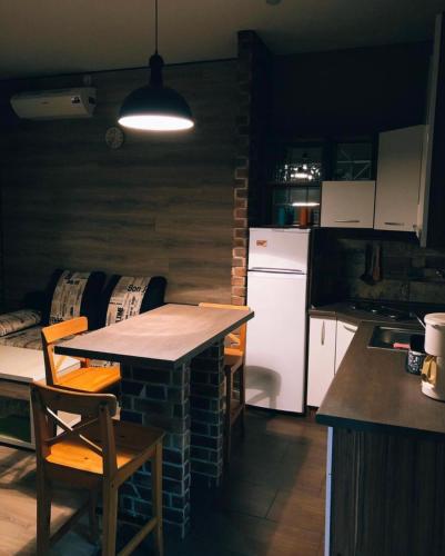 een keuken met een aanrecht, een tafel en een koelkast bij VIP apart 419 in Tbilisi City