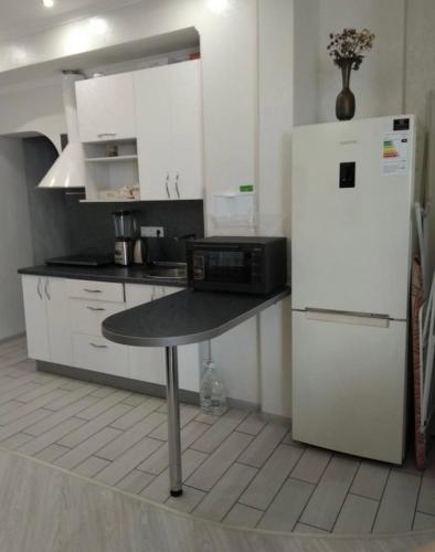 een keuken met een witte koelkast en een tafel bij VIP apart 419 in Tbilisi City