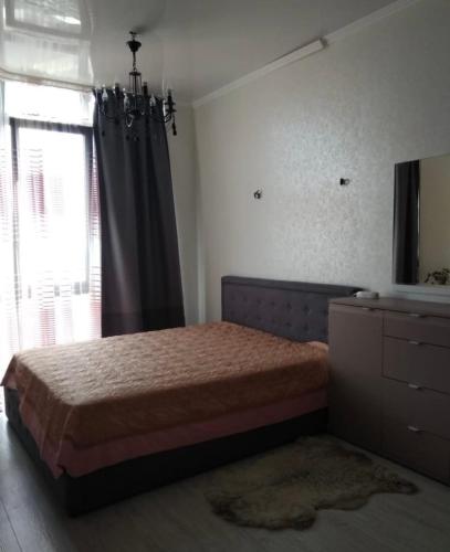 een slaapkamer met een bed, een dressoir en een raam bij VIP apart 419 in Tbilisi City