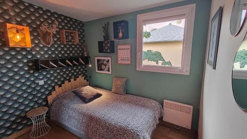 una camera da letto con un letto e una finestra di CHALET DE L'EPINETTE a Plourhan