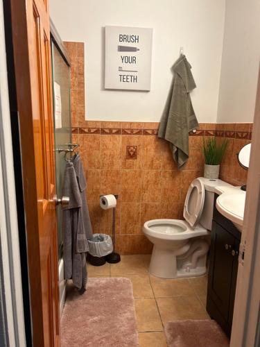 a bathroom with a toilet and a sink at A Spacious & Blissful Stay in queens in Laurelton