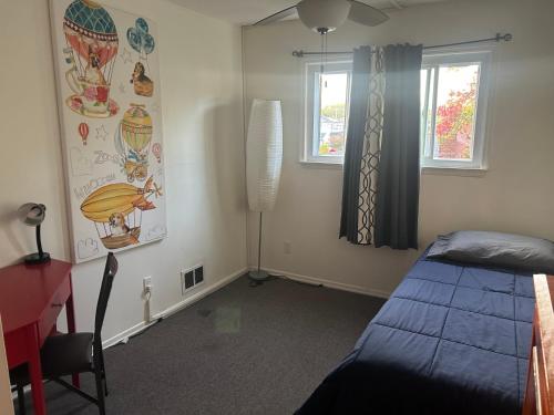 a bedroom with a bed and a desk and a window at A Spacious & Blissful Stay in queens in Laurelton