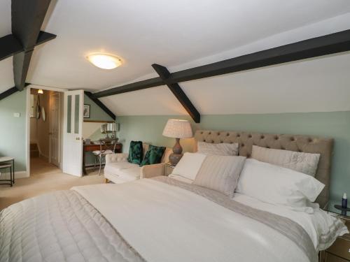 um quarto com uma grande cama branca e um sofá em The Gate House em Cirencester