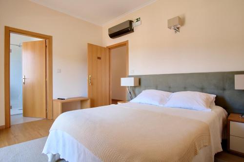 a bedroom with a large white bed in a room at Cerca da Estrela in Matança