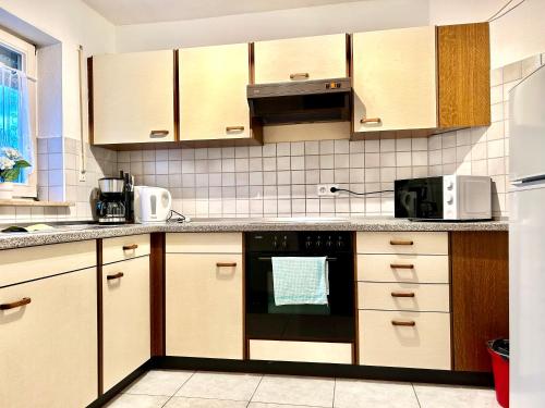 eine Küche mit Holzschränken und einem schwarzen Backofen in der Unterkunft Lotus Apartment in Fichtenberg