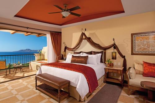 a bedroom with a large bed and a balcony at Secrets Puerto Los Cabos Golf & Spa18+ in San José del Cabo