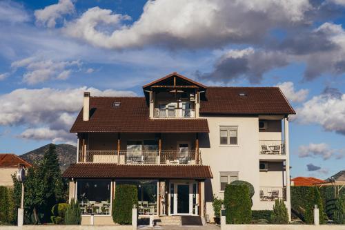 a large white building with a brown roof at To Spiti tis Sofias in Kastoria