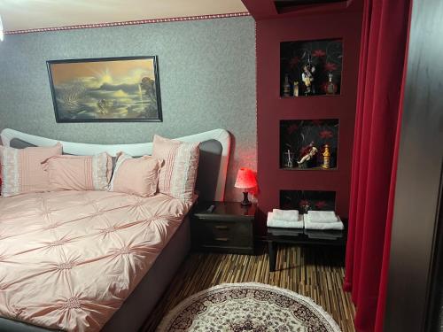 1 dormitorio con 1 cama y paredes rojas en Casa verde, en Săcălaz