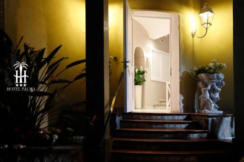 a hallway with stairs and a door with a mirror at Hotel Palma in Castellammare di Stabia