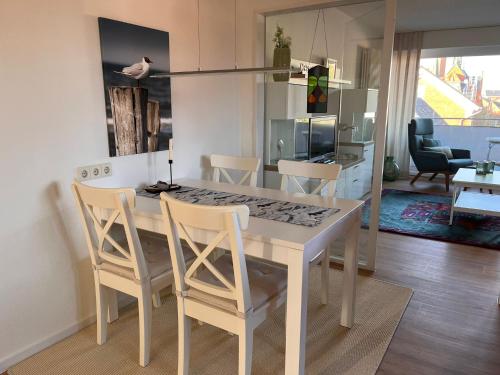 eine Küche und ein Esszimmer mit einem weißen Tisch und Stühlen in der Unterkunft Ferienwohnung Antje auf Borkum in Borkum