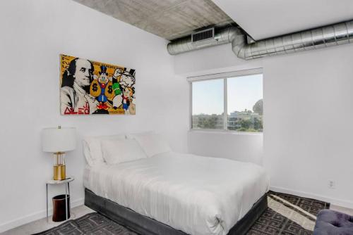 a white bedroom with a bed and a window at The Sunset Blvd luxury high-rise, 180 city views in Los Angeles