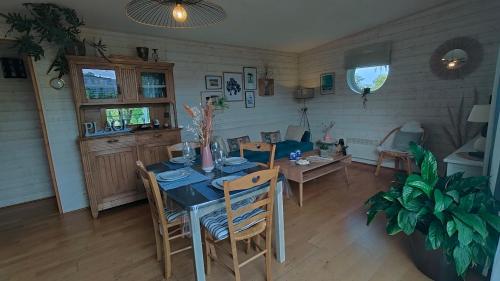 una sala da pranzo con tavolo e alcune sedie di CHALET DE L'EPINETTE a Plourhan