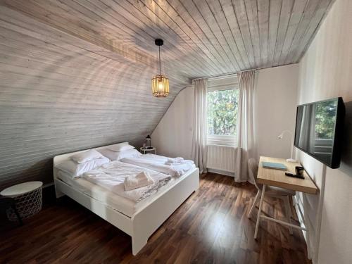 een slaapkamer met een wit bed en een houten vloer bij Schönes Zimmer in gepflegter Wohnung - 1 in Paderborn
