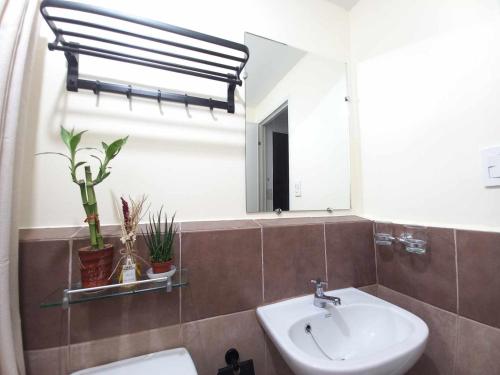 a bathroom with a sink and a mirror and a toilet at My Arezzo 1 BR Condo in Davao City