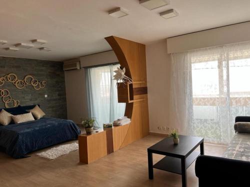 um quarto com uma cama e uma sala de estar em MODERNE APPART PLEIN CENTRE em Fez