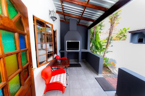 a room with a balcony with red chairs and a tv at Kleinplasie Guesthouse in Springbok