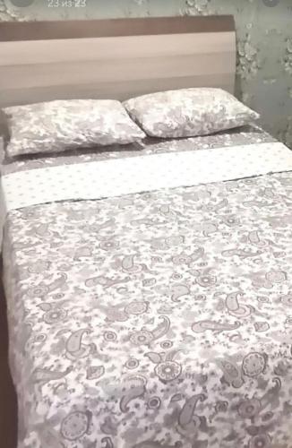 uma cama com um cobertor e almofadas em VIP apart 421 em Tbilisi