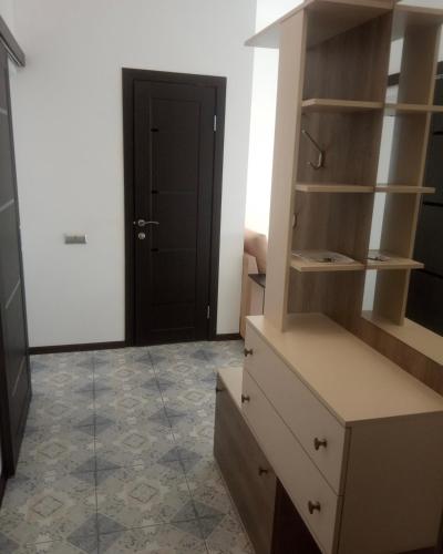 um quarto com uma cómoda e uma porta preta em VIP apart 421 em Tbilisi