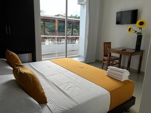 Paz de Ariporo的住宿－HOTEL EXBINT RESORT，一间卧室配有一张带窗户和桌子的床