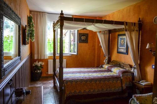 1 dormitorio con cama con dosel en una habitación en Hosteria Las Viñas, en Noja