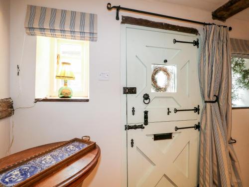 a white door in a room with a window at Peppermint Cottage in Petworth