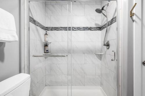 La salle de bains est pourvue d'une douche avec une porte en verre. dans l'établissement Walnut, 3BR Townhom Near Downtown, Beach and Wineries, à Traverse City