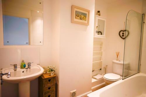 a bathroom with a sink and a toilet and a tub at 9 Solent Landing in Bembridge