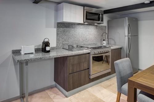 a kitchen with a stove and a refrigerator at MX Grand Suites in Mexico City